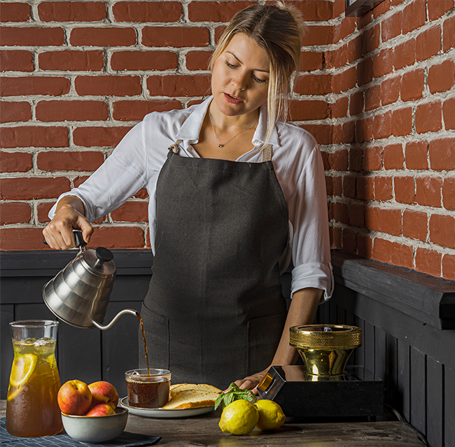 Café lifestyle photography of a barista pouring coffee
